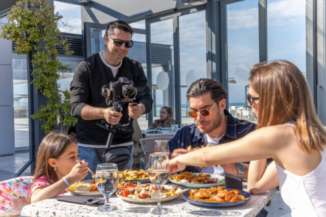 Family enjoying meal at restaurant during lifestyle commercial video shoot in Greece